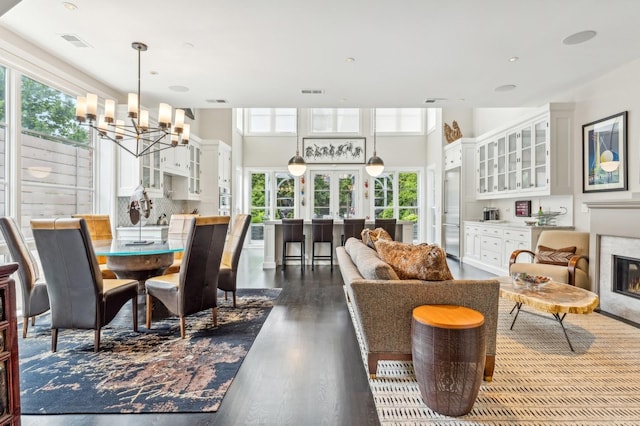 dining space featuring visible vents, french doors, dark wood-type flooring, and a glass covered fireplace