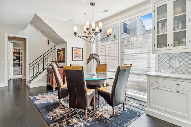 dining space with a notable chandelier, visible vents, stairway, and dark wood-style flooring