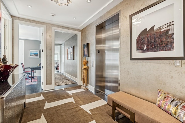 hallway with elevator, recessed lighting, and baseboards