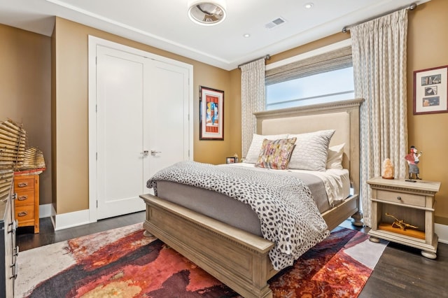 bedroom featuring a closet, visible vents, baseboards, and wood finished floors