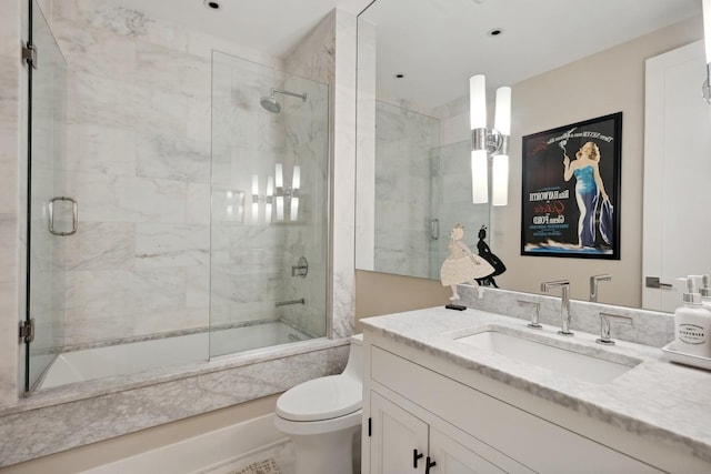 full bath featuring bath / shower combo with glass door, vanity, and toilet