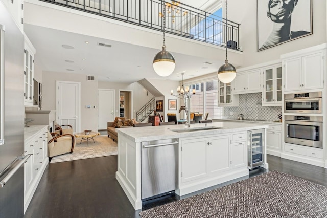 kitchen with a sink, light countertops, a notable chandelier, and stainless steel appliances