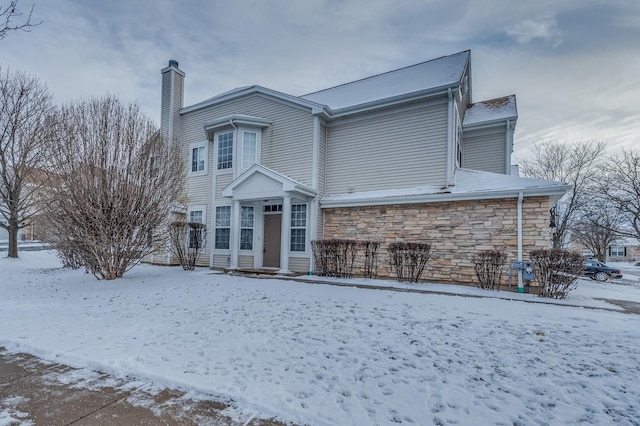 view of front of home featuring stone siding and a chimney