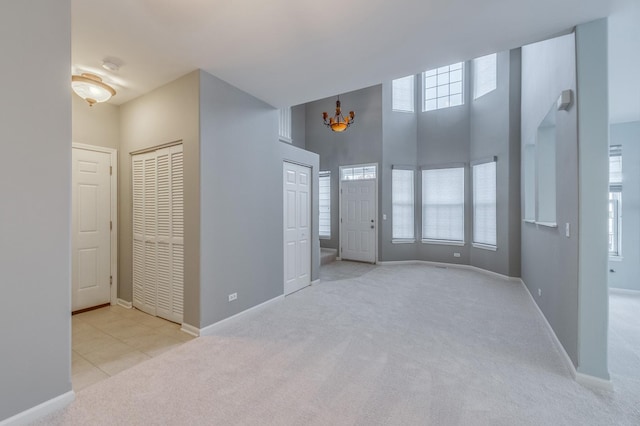 interior space with baseboards, plenty of natural light, a high ceiling, and carpet flooring