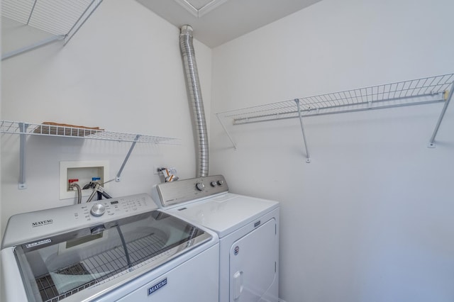 clothes washing area featuring washing machine and dryer and laundry area