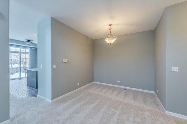 spare room with light carpet and baseboards