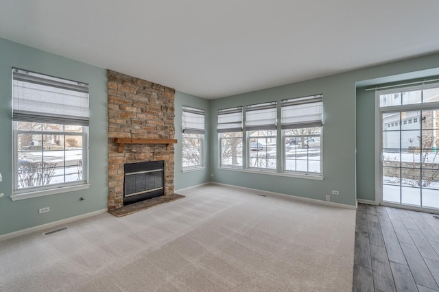 unfurnished living room featuring a fireplace, baseboards, and a healthy amount of sunlight