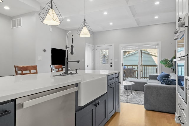 kitchen with light wood-type flooring, visible vents, coffered ceiling, recessed lighting, and appliances with stainless steel finishes