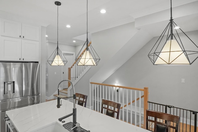 kitchen featuring recessed lighting, stainless steel fridge, pendant lighting, and a sink