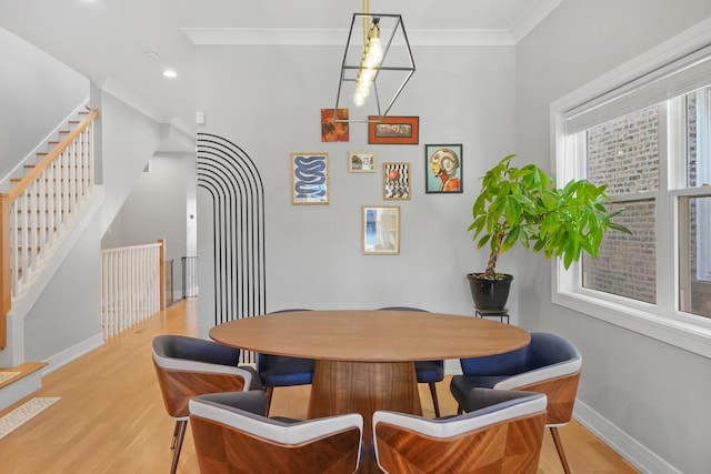 dining area featuring light wood finished floors, crown molding, baseboards, stairs, and recessed lighting