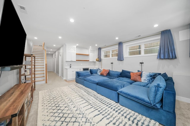 living area featuring visible vents, baseboards, stairs, light carpet, and recessed lighting