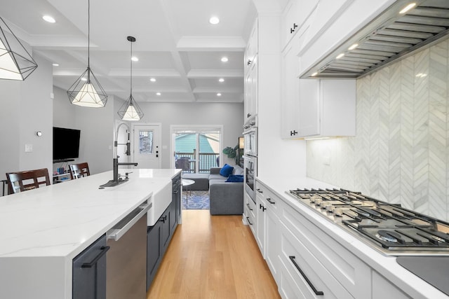 kitchen with premium range hood, appliances with stainless steel finishes, light wood-style floors, coffered ceiling, and white cabinetry