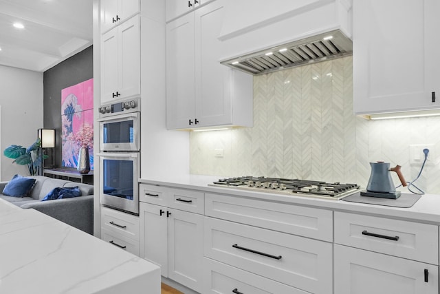 kitchen featuring stainless steel appliances, backsplash, and white cabinetry