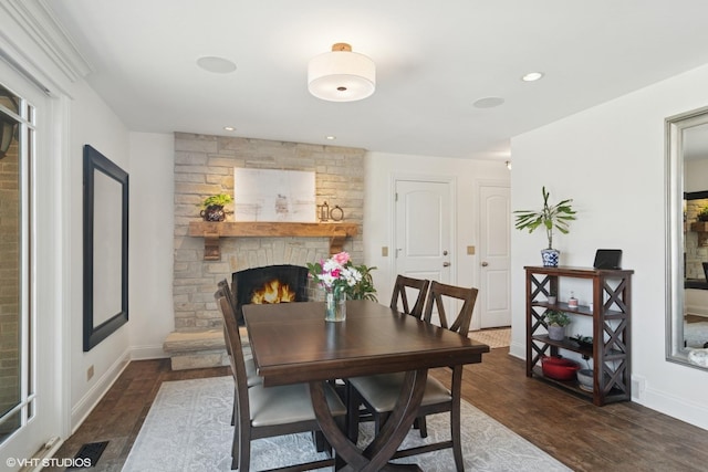 dining area featuring recessed lighting, baseboards, dark wood-style flooring, and a fireplace