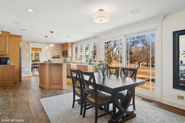 dining room featuring hardwood / wood-style floors, plenty of natural light, baseboards, and visible vents