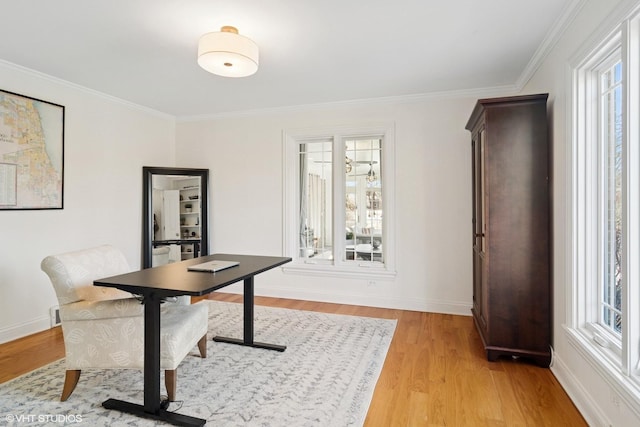 home office featuring a wealth of natural light, light wood-type flooring, baseboards, and ornamental molding