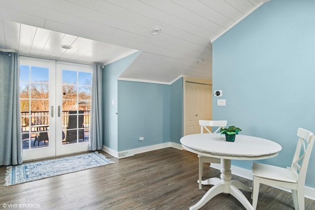 dining room with ornamental molding, dark wood finished floors, wooden ceiling, baseboards, and vaulted ceiling