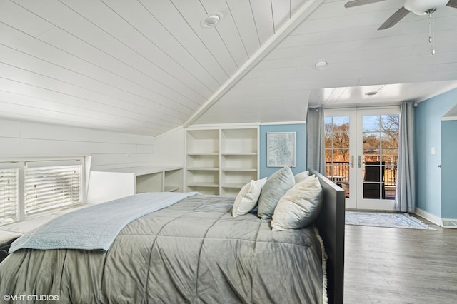 bedroom featuring wood finished floors, baseboards, lofted ceiling, french doors, and access to outside