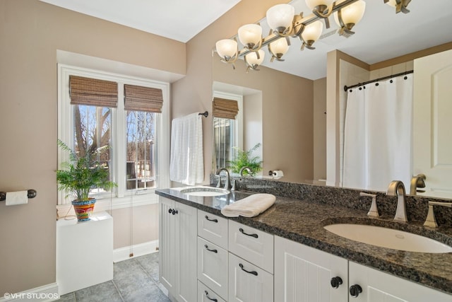 bathroom with a sink, visible vents, double vanity, and tile patterned floors