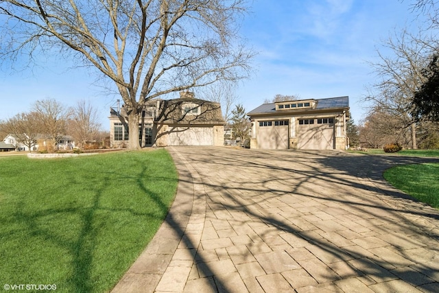 view of front of home featuring an outbuilding, a garage, driveway, and a front yard