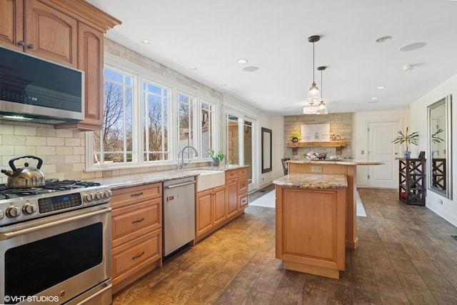 kitchen with a sink, decorative backsplash, a center island, and stainless steel appliances