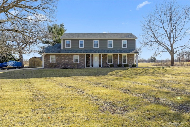 view of front of house with a front yard, a gate, and brick siding