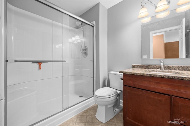 bathroom featuring tile patterned floors, toilet, a stall shower, and vanity