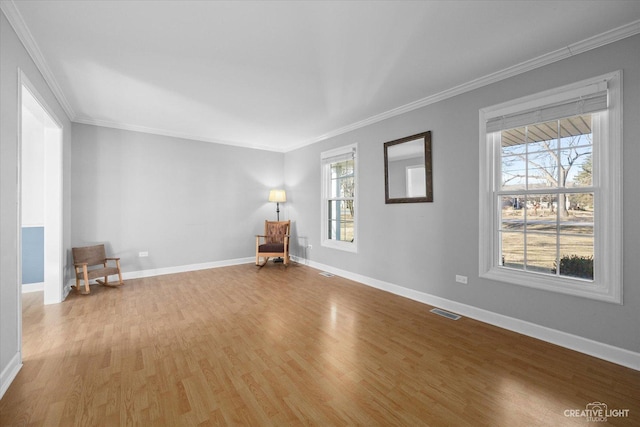 unfurnished room featuring visible vents, crown molding, baseboards, and wood finished floors