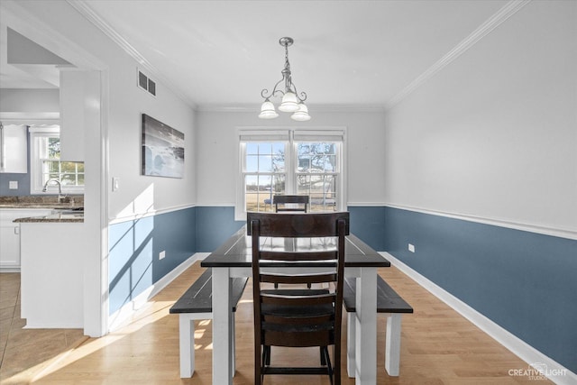 dining area featuring crown molding, visible vents, and light wood-type flooring