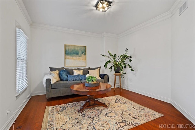 living area featuring visible vents, crown molding, baseboards, and wood finished floors