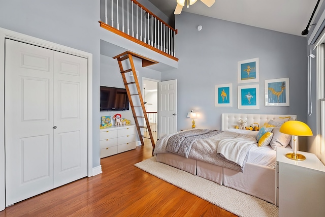 bedroom with a high ceiling and wood finished floors