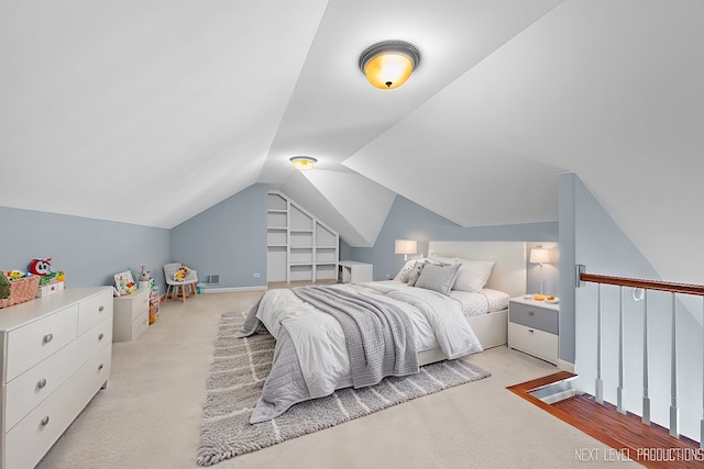 bedroom with lofted ceiling, light colored carpet, and visible vents