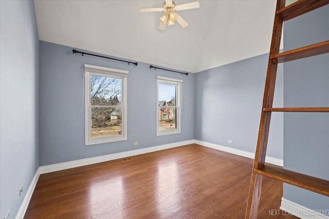 spare room featuring baseboards, wood finished floors, and a ceiling fan