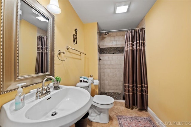 full bath with tile patterned flooring, a shower stall, baseboards, toilet, and a sink