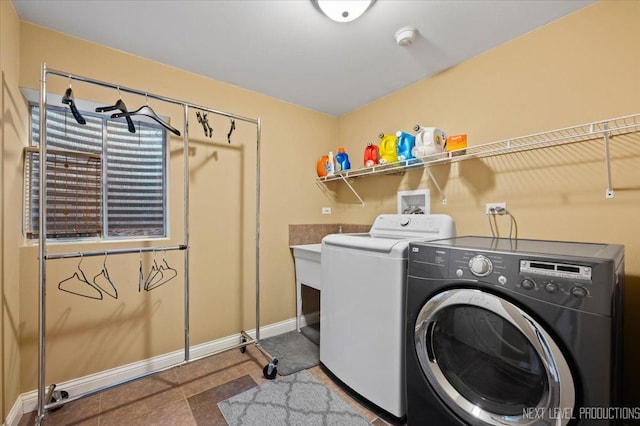 laundry area featuring laundry area, baseboards, and washer and clothes dryer