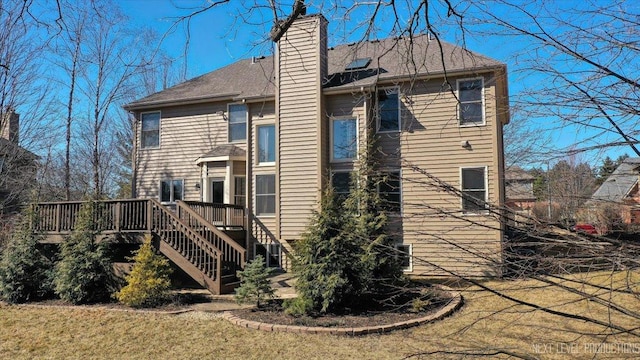 rear view of house with stairs, a deck, and a chimney