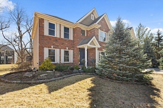 view of front of house with brick siding and a front lawn