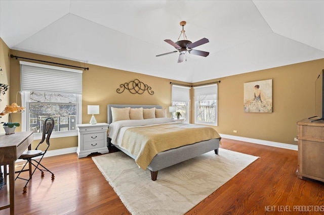 bedroom featuring a ceiling fan, lofted ceiling, wood finished floors, and baseboards