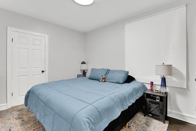 bedroom featuring wood finished floors and baseboards