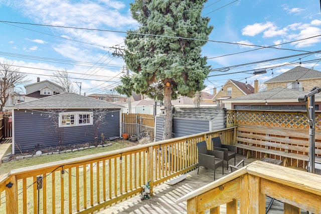 wooden terrace featuring an outbuilding and fence