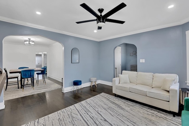 living room featuring wood finished floors, a ceiling fan, arched walkways, and ornamental molding