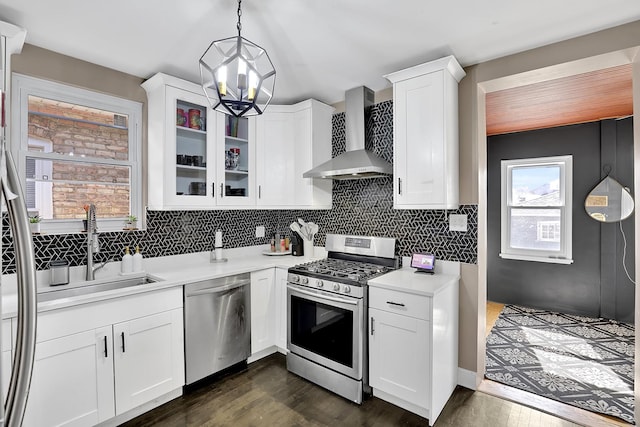 kitchen with stainless steel appliances, backsplash, wall chimney exhaust hood, and light countertops