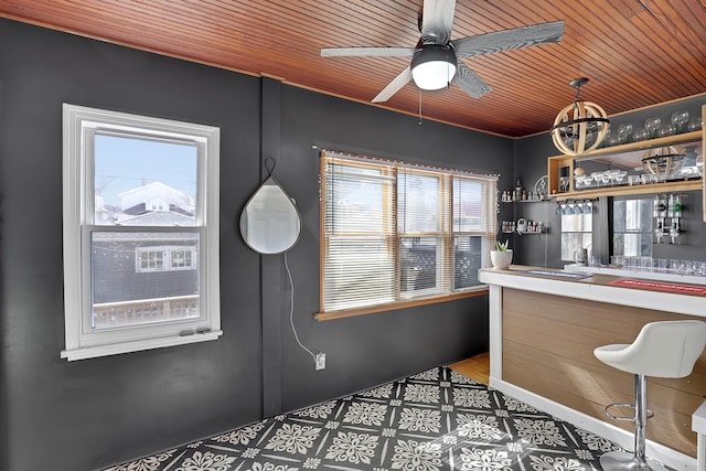 bar with bar area, ceiling fan, and wooden ceiling