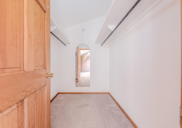 spacious closet with arched walkways and carpet flooring