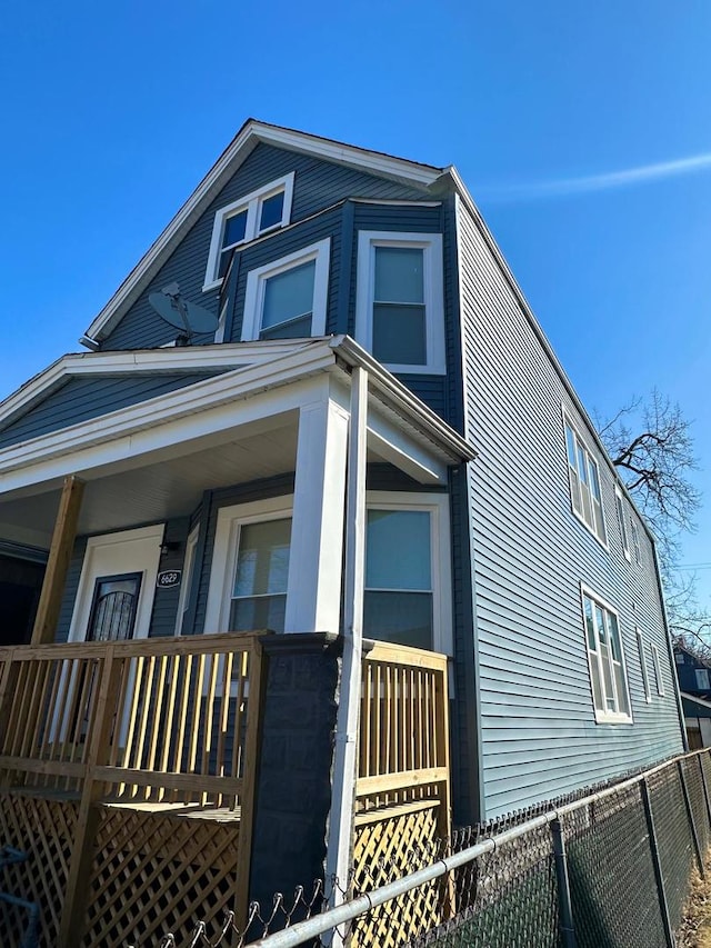 view of front of home featuring a porch and fence