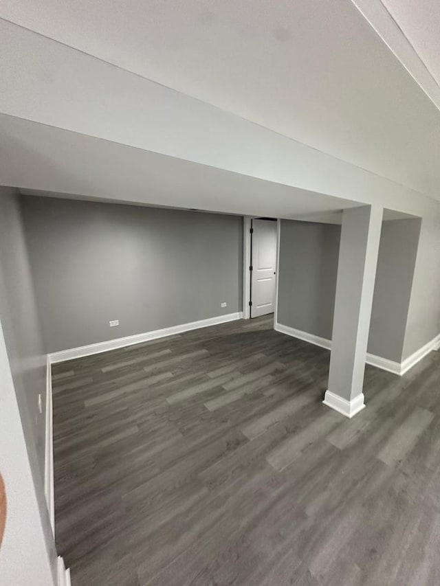 finished below grade area featuring baseboards and dark wood-style floors