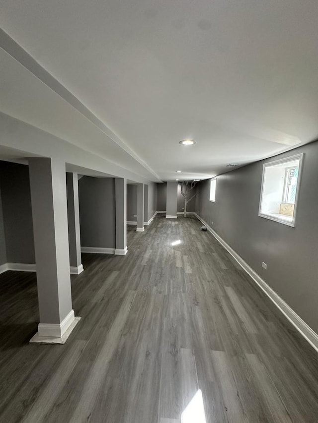 basement featuring dark wood finished floors and baseboards