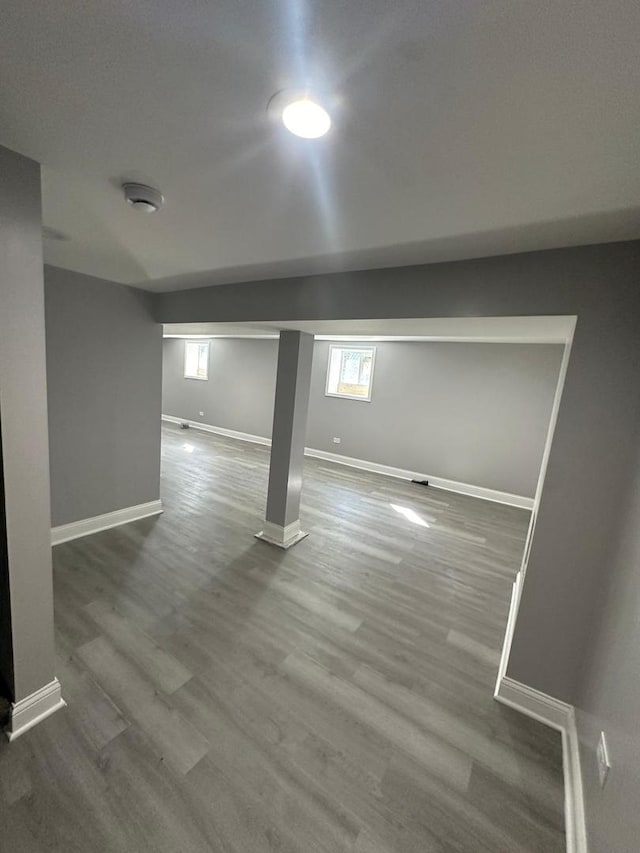 basement with baseboards and wood finished floors