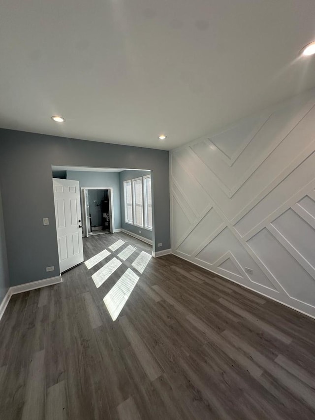 unfurnished living room with recessed lighting, baseboards, and dark wood-type flooring