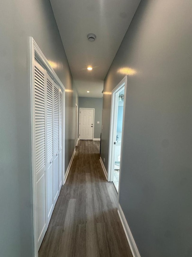 hall with dark wood-style floors and baseboards